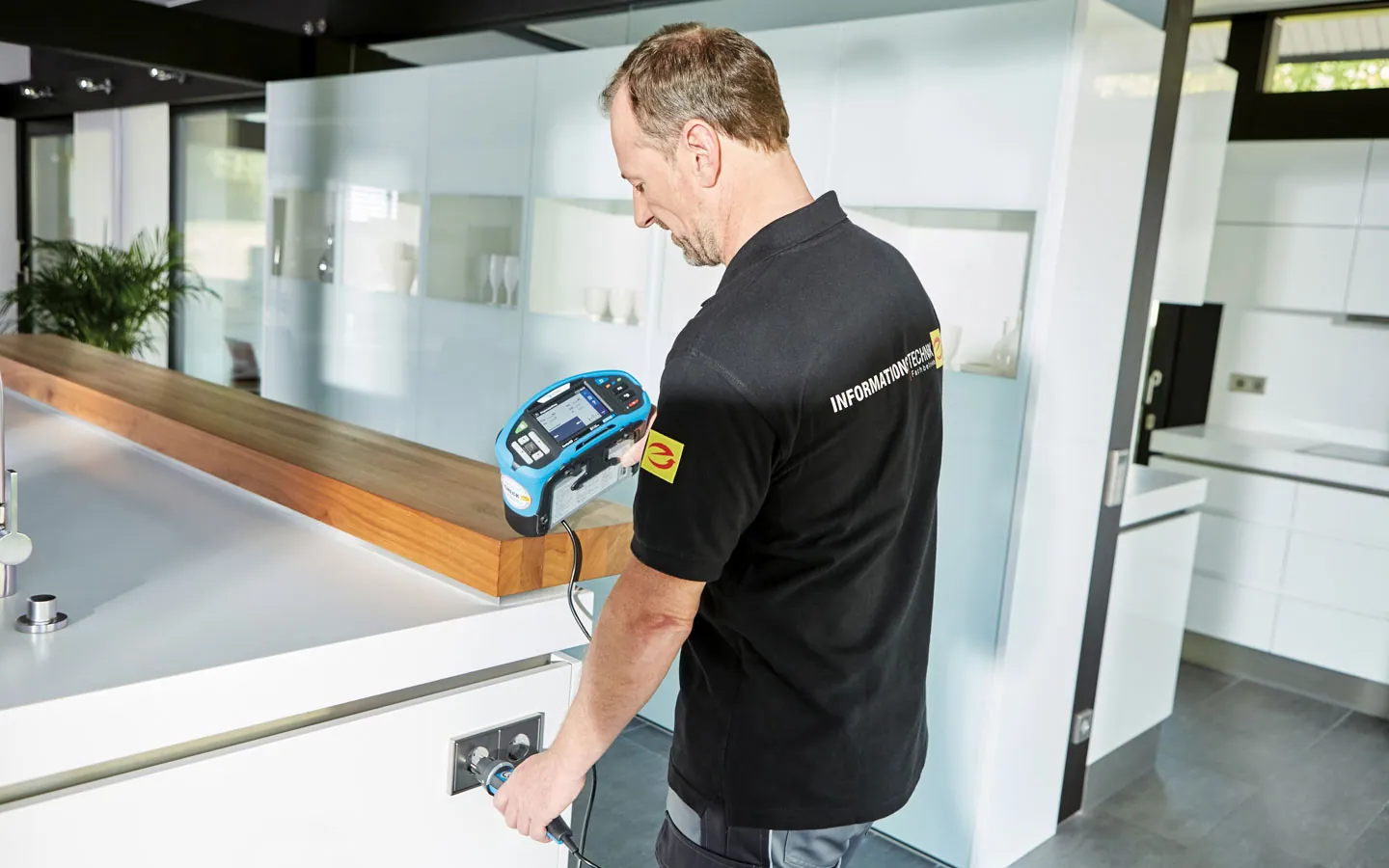 E-CHECK - Mitarbeiter prüft die Steckdosen in der Küche &middot; Elektro Busch GmbH