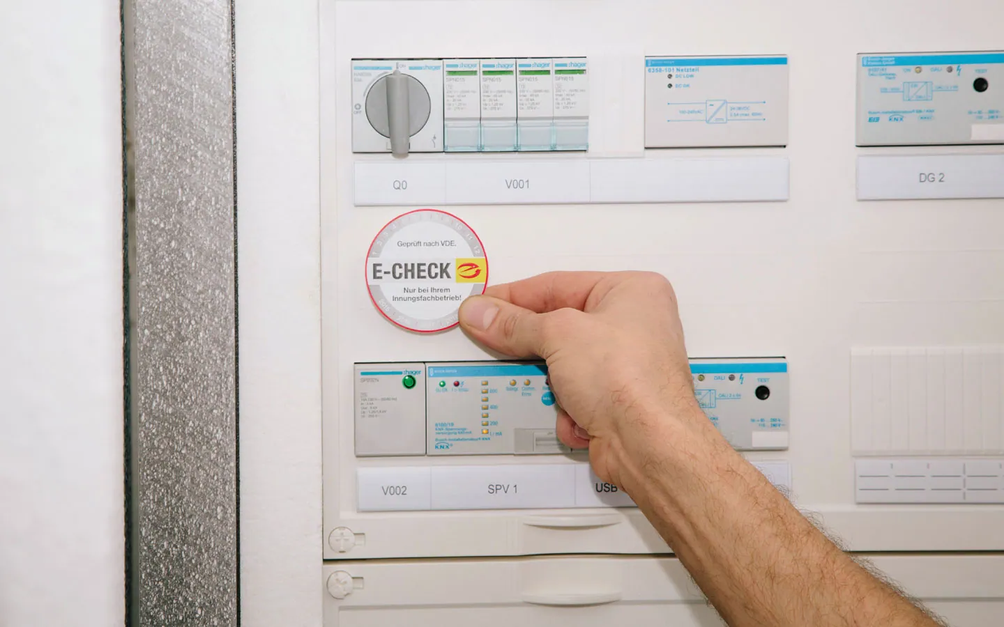 E-CHECK - Mitarbeiter klebt in der Verteilung die E-CHECK Plakette an &middot; Elektro Busch GmbH
